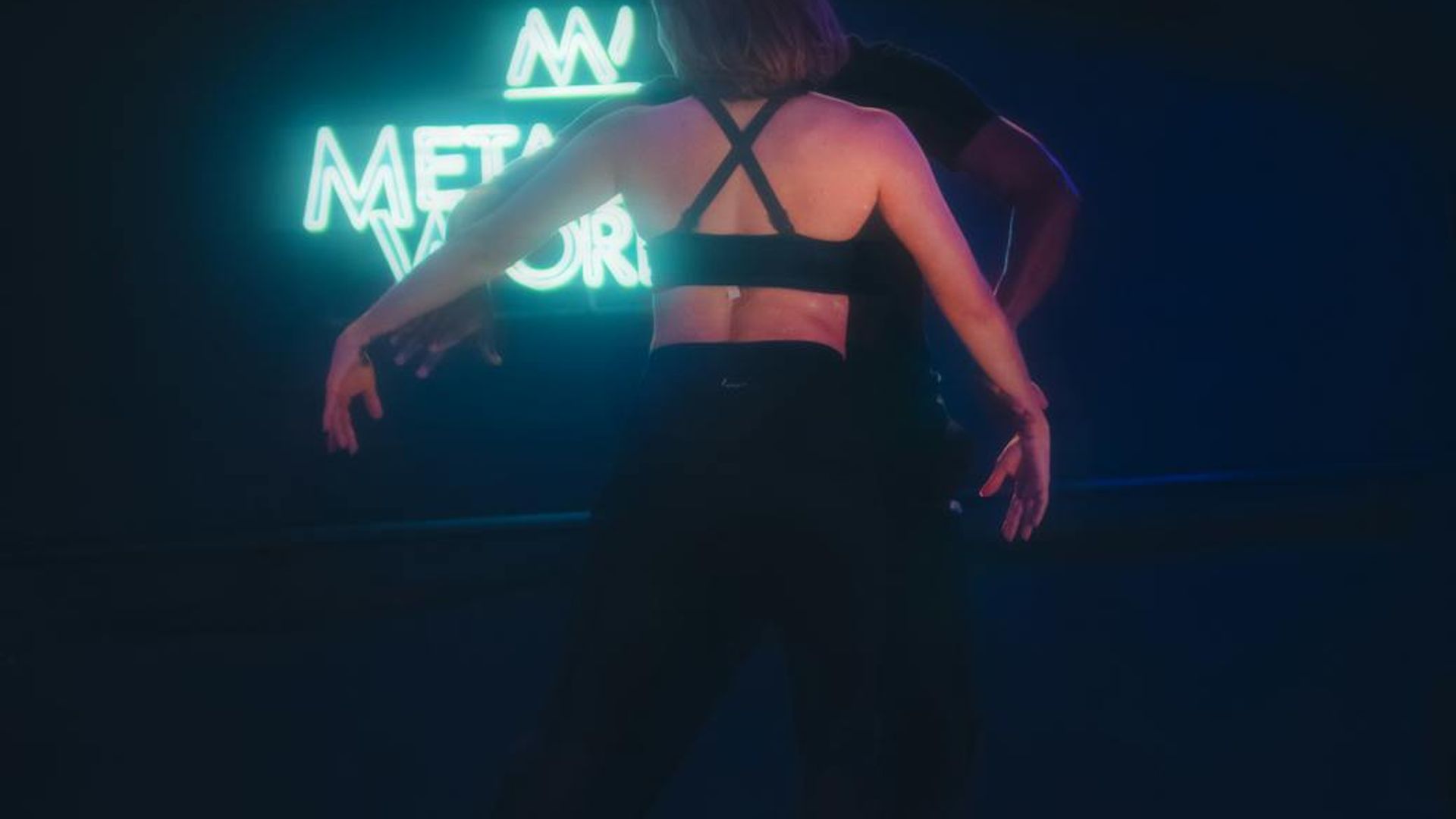 Active person moving in a dark studio with violet neon lights